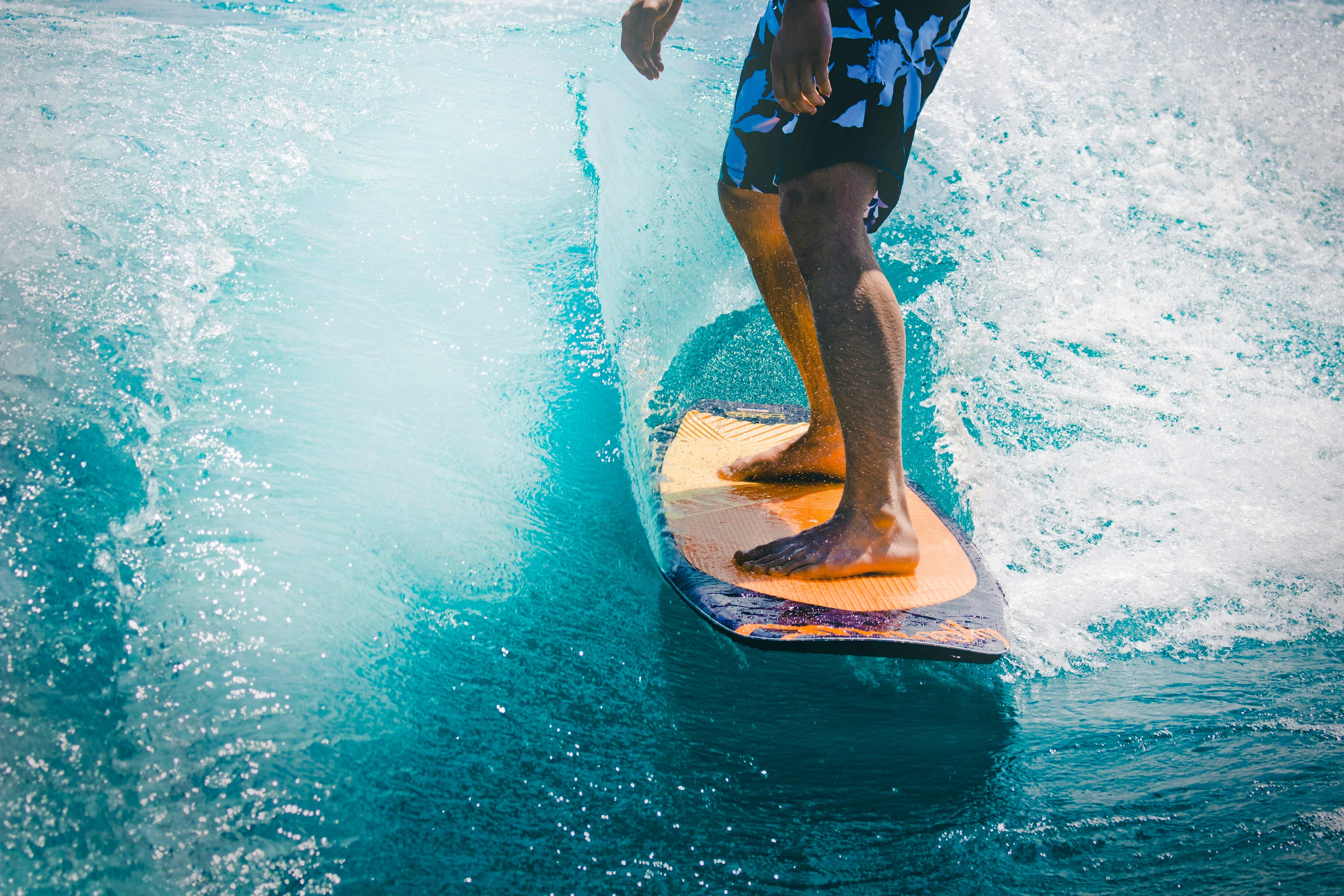 Surfer riding a wave on an orange surfboard
